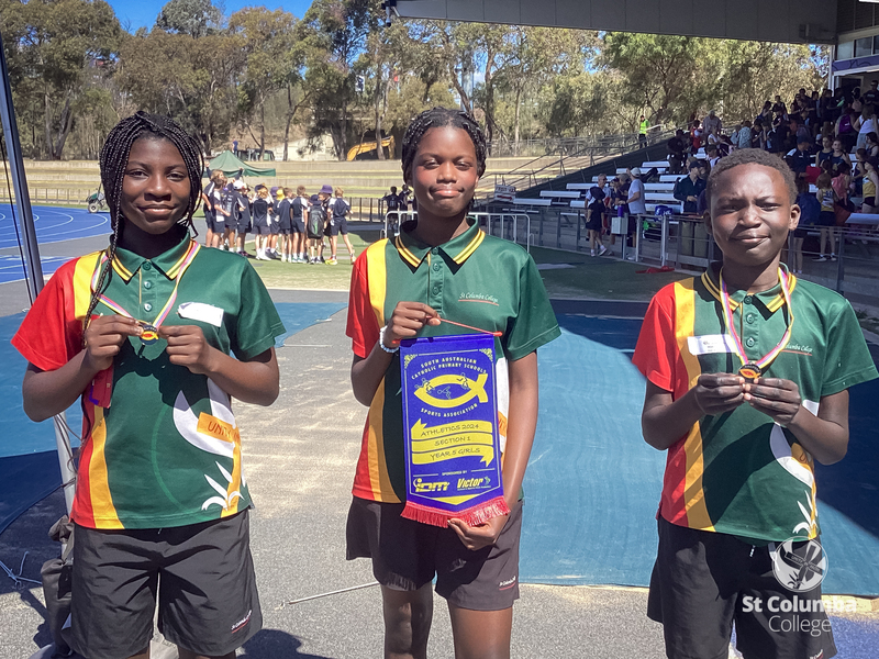 Catholic Schools Athletic Carnival. Jodie holds the Year 5 winning pennant, with Prestige and Makol the Year 4 Age Champions