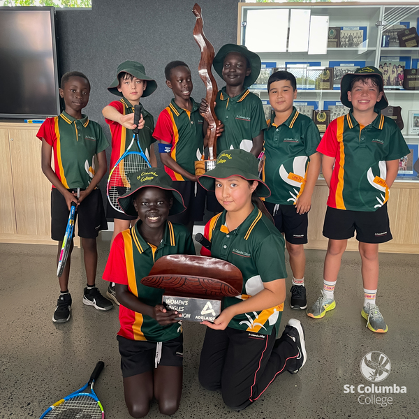 Year 4 Students holding Men's and Women's Singles Trophies